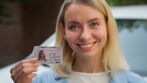 Cheerful Caucasian lady smiling female girl auto transport owner demonstrating driver license in