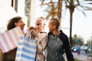 Happy women friends shopping laughing and having fun in the city