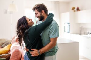 Relocation concept. A smiling cheerful multiracial couple in embraces lookin in each other eyes
